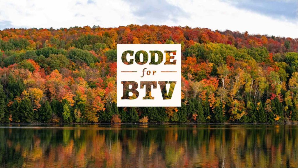 White square Code for BTV logo with transparent letters in front of trees with fall foliage.